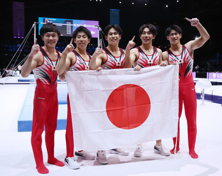 男子団体総合で優勝し、日の丸を手にポーズを取る(右から)橋本大輝、南一輝、萱和磨、杉本海誉斗、千葉健太=3日、ベルギー・アントワープ