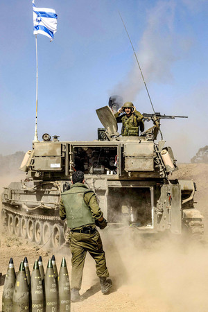 ６日、イスラエル南部のガザ境界付近から砲撃を行う兵士（ＡＦＰ時事）