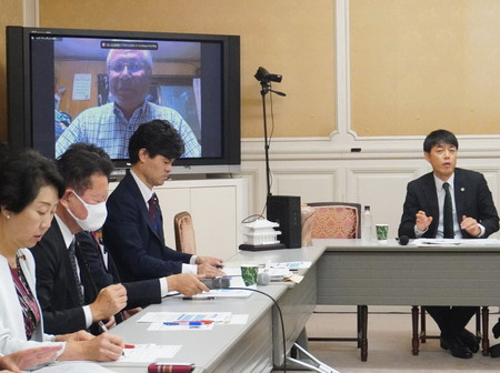 国会議員らの前で語る阿部克臣弁護士(右)と被害者の橋田達夫さん(モニター内)=7日、国会内