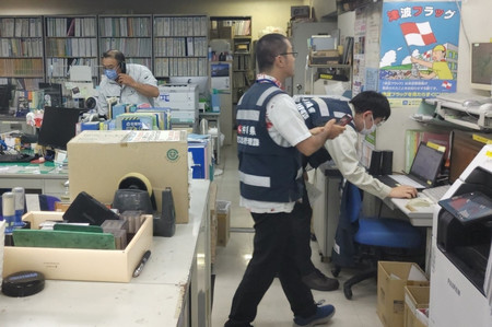 Jアラートを受け、対応に当たる沖縄県の職員ら=21日夜、那覇市の同県庁