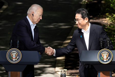 バイデン米大統領(左)と握手する岸田文雄首相=8月18日、ワシントン近郊キャンプデービッド山荘(EPA時事)
