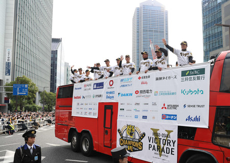 神戸市内で行われた優勝パレードで手を振る阪神の選手ら＝２３日午前、神戸市中央区
