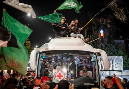２６日、ヨルダン川西岸ラマラで、釈放されたパレスチナ人を運ぶバスを取り囲み歓迎する人々（ＡＦＰ時事）