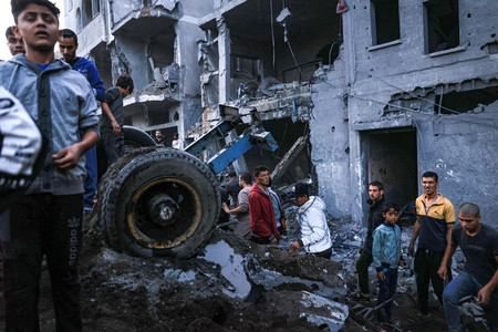 ３日、パレスチナ自治区ガザの南部ラファで、イスラエル軍の攻撃後に被害を確認する人々（ＡＦＰ時事）