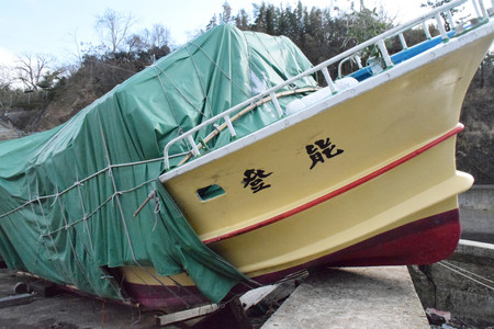 津波で流され、堤防に乗り上げる遊覧船＝１９日、石川県志賀町