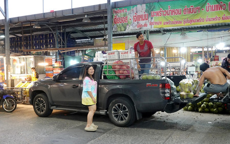 バンコク近郊のアイヤラー市場で、ピックアップトラックに果物などを積み込む人たち＝２６日