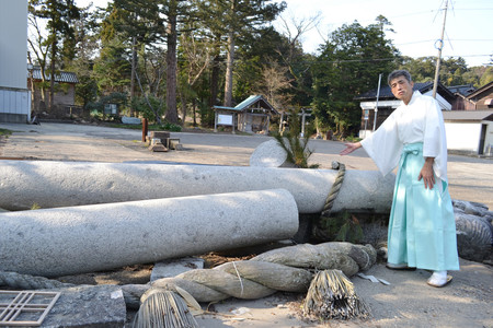 地震と津波で倒壊した鳥居について説明する須須神社の猿女豊信さん＝１５日、石川県珠洲市