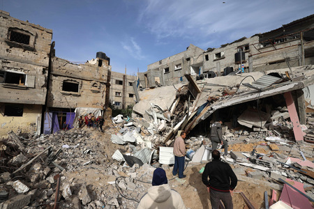 パレスチナ自治区ガザ最南部ラファで、崩壊した建物を調べる人々＝３月２７日、パレスチナ・ラファ（ＡＦＰ時事）