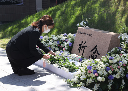熊本地震の犠牲者追悼式で献花する参列者＝１４日午前、熊本市中央区