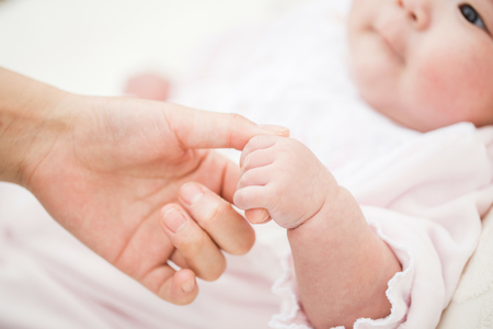 母親の指を握る赤ちゃん（資料写真）