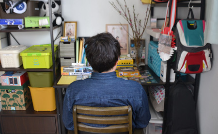 知床観光船事故で行方不明となっている息子の学習机に座る男性＝３月１１日、北海道