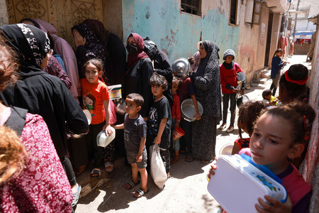 パレスチナ自治区ガザ最南部ラファで、食料を受け取るために並ぶ避難民の子供ら＝１９日（ＡＦＰ時事）