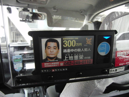 タクシーの車内モニターに流れる、元暴力団組員上地恵栄容疑者の手配写真＝２０１２年１０月、東京都内