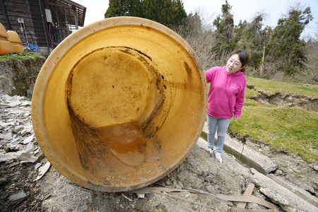 地震で転倒し、ほぼ全てが流出した「いしる」のたるを見つめる母の南谷良枝さん＝１日、石川県輪島市（南谷美有さん提供）