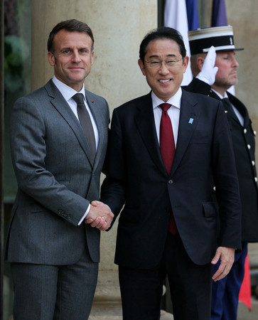首脳会談を前に握手する岸田文雄首相（右）とフランスのマクロン大統領＝２日、パリ（ＡＦＰ時事）