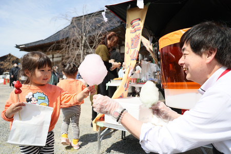 被災地で開かれた子ども食堂で、綿菓子を受け取る子ども（左）＝３月３１日、石川県珠洲市