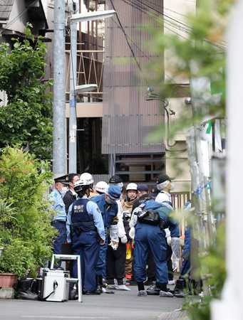 火災があった現場付近を調べる消防隊員と警察官ら＝２３日午後、東京都品川区