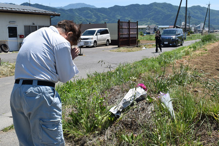 長野４人殺害事件から１年となり、現場で手を合わせる男性＝２５日午後、長野県中野市