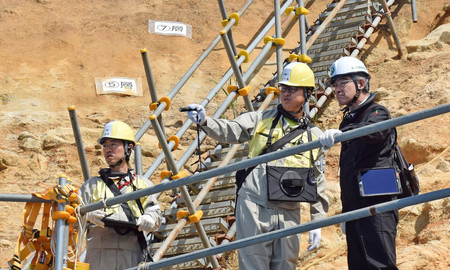 日本原子力発電敦賀原発２号機の敷地内の断層について、トレンチ（試掘溝）内で説明を聞く原子力規制委員会の石渡明委員（右）＝７日午前、福井県敦賀市