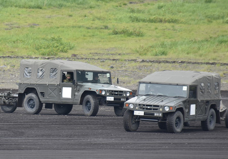 陸上自衛隊の「富士総合火力演習」に参加し、けん引中の陸自の高機動車＝５月２６日、静岡県の東富士演習場