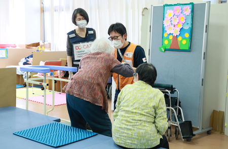 石川県輪島市の避難所で要介護者（中央手前）を介助する医療関係者＝１月３１日