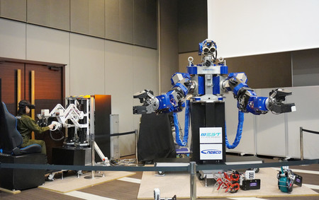 ＪＲ西日本が鉄道設備のメンテナンスに導入する人型ロボット。操縦席（左）から遠隔操作ができる＝２７日午後、東京都港区
