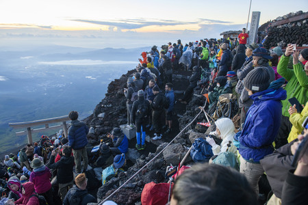 ご来光を待つ登山者で混雑する富士山頂＝２０２３年８月（山梨県提供）