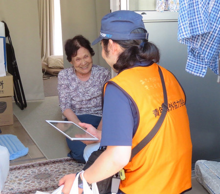 仮設住宅を見回り、熱中症について注意を呼び掛けるボランティア＝１９日、石川県輪島市