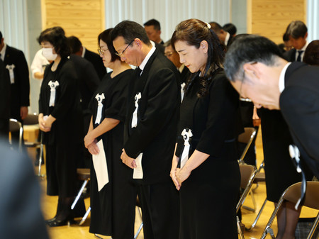 熊本豪雨の犠牲者追悼式で、黙とうする遺族ら＝３０日午前、熊本県人吉市