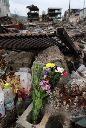 地震により焼失した朝市通り周辺に供えられた花＝３０日午前、石川県輪島市