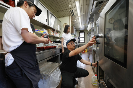 被災した地元の料理人らで立ち上げた飲食店のプレオープンを前に、開店準備をする池端隼也さん（右）＝１日午後、石川県輪島市