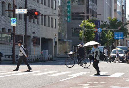 猛暑の中、横断歩道を渡る人々＝４日午後、静岡市