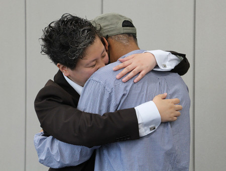 判決後、代理人弁護士と喜んで抱き合うアフリカ北部出身の男性（右）＝４日午後、大阪市北区