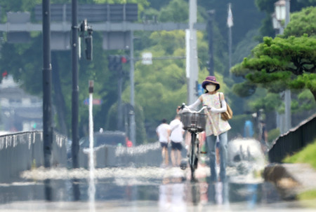 気温が上昇し、皇居前の歩道では蜃気楼（しんきろう）の一種「逃げ水」が見られた＝７日午後、東京都千代田区