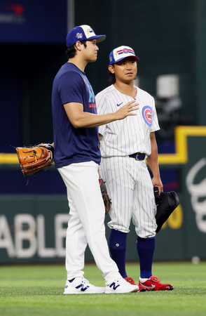 オールスター戦前日の練習の合間に会話するカブスの今永（右）とドジャースの大谷＝１５日、アーリントン