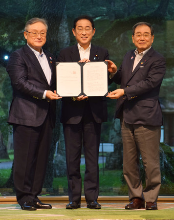 経団連の十倉雅和会長（右）、東原敏昭副会長（左）から総括文書を受け取る岸田文雄首相＝１９日午後、長野県軽井沢町