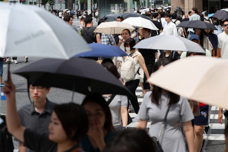 日傘を差して交差点を歩く人たち＝２０日午後、東京・銀座