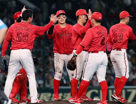 延長戦の末、阪神に勝利し、喜ぶ小園（右から４人目）ら広島ナイン＝２０日、甲子園