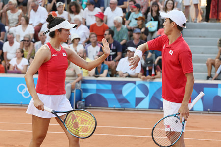 混合ダブルス１回戦、ポイントを奪いタッチを交わす錦織圭と柴原瑛菜（左）＝２９日、パリ