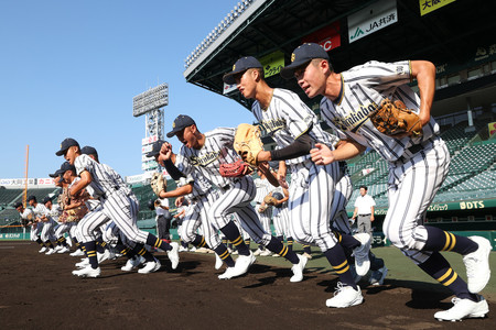 グラウンドに駆け出す白樺学園の選手＝２日、甲子園