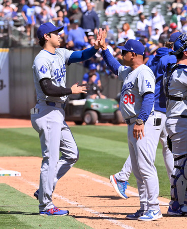 アスレチックスに勝ち、ロバーツ監督（右）とタッチを交わすドジャースの大谷＝４日、オークランド