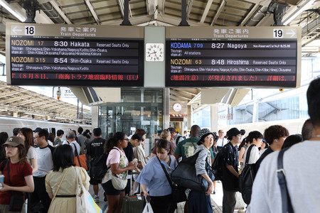 帰省客らで混雑するＪＲ東京駅の東海道新幹線ホーム。電光掲示板には南海トラフ地震臨時情報（巨大地震注意）が表示されていた＝１０日午前