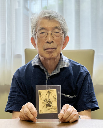 全国戦没者追悼式の神奈川県遺族代表の高橋和彦さん。手にしている写真は戦死した兄冨彦さん＝１０日午後、川崎市