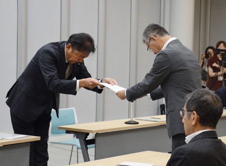 新潟県柏崎市の桜井雅浩市長（右）に文書を手渡す東京電力ホールディングスの小早川智明社長＝２２日午前、同市