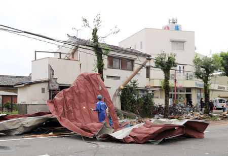 台風１０号の影響で飛ばされたものを撤去する作業員＝２９日午後、宮崎市