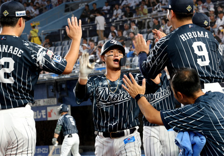 １回、先制２ランを放ち、ベンチ前で出迎えられる西武の佐藤龍（中央）＝２９日、ゾゾマリン