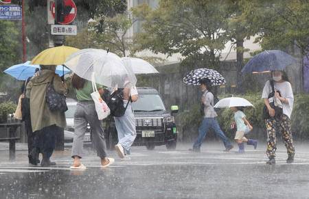 雨が降る中、傘を差して歩く人たち＝３０日午前、東京都世田谷区