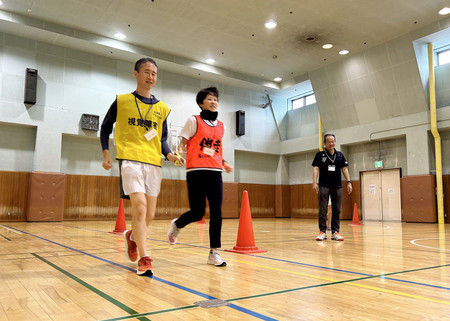 「伴走者養成研修会」に参加した視覚障害ランナー（左）と伴走者（中央）＝７月１５日、東京都新宿区