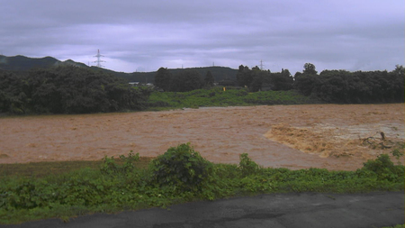 大雨で増水した日向川＝７月２５日、山形県遊佐町（同県提供）