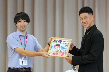 色紙を手に笑顔を見せる車いすテニスの小田凱人選手（右）＝６月２１日、愛知県一宮市